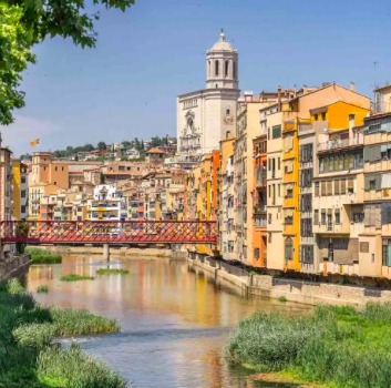 Pastel houses and the cathedral tower above the Onyar river in Girona